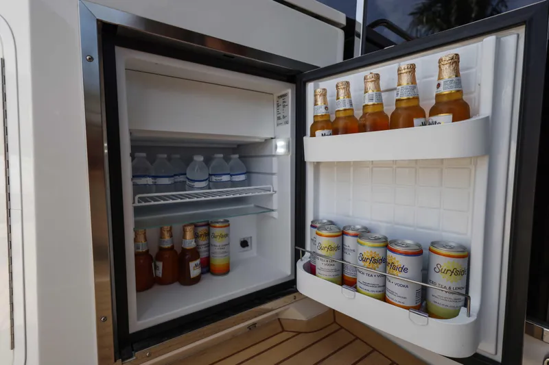 Slide: The Image of Open mini fridge on 2016 Cruisers Yachts 45 Cantius, stocked with drinks and beverages. - 29