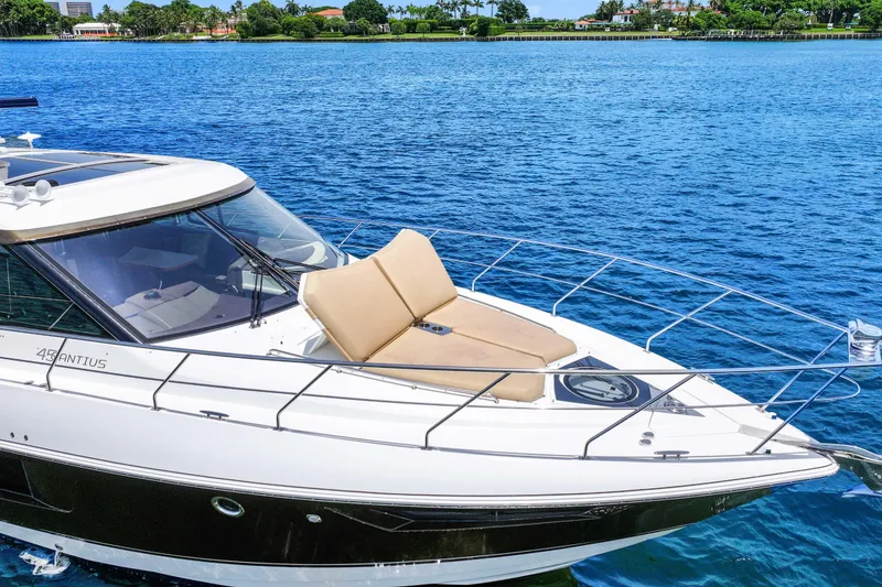 Slide: The Image of 2016 Cruisers Yachts 45 Cantius on serene blue water, featuring sleek design and sunbathing area. - 18