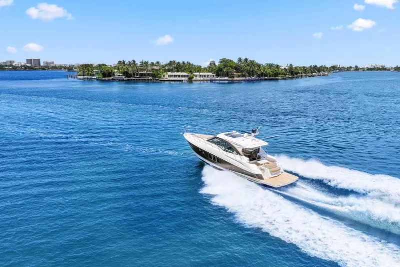 Slide: The Image of 2016 Cruisers Yachts 45 Cantius cruising on blue waters near a lush island. - 10