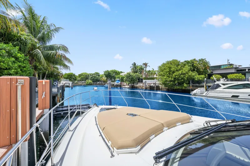 Slide: The Image of 2016 Cruisers Yachts 45 Cantius docked in a serene, tropical marina setting. - 59