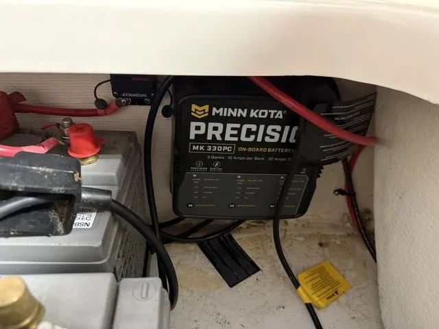 Slide: The Image of A Minn Kota Precision charger is installed next to a battery in a boat. - 28