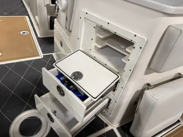Slide: The Image of The 2020 Cobia 240DC features open storage compartments and drawers on a sleek, modern deck. - 16