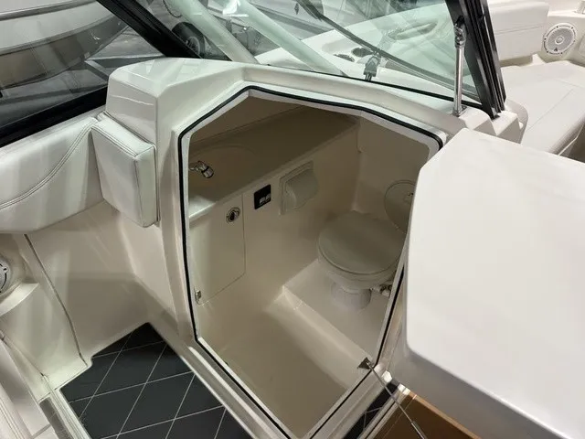 Slide: The Image of The image shows the interior of a 2020 Cobia 240DC with a small toilet. - 25