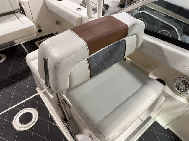 Slide: The Image of A sleek seat with white and brown upholstery in a Cobia 240DC boat. - 26