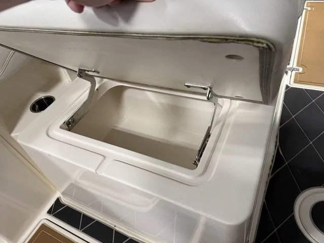 Slide: The Image of An open storage compartment on a 2020 Cobia 240DC boat, featuring a cushioned lid. - 17