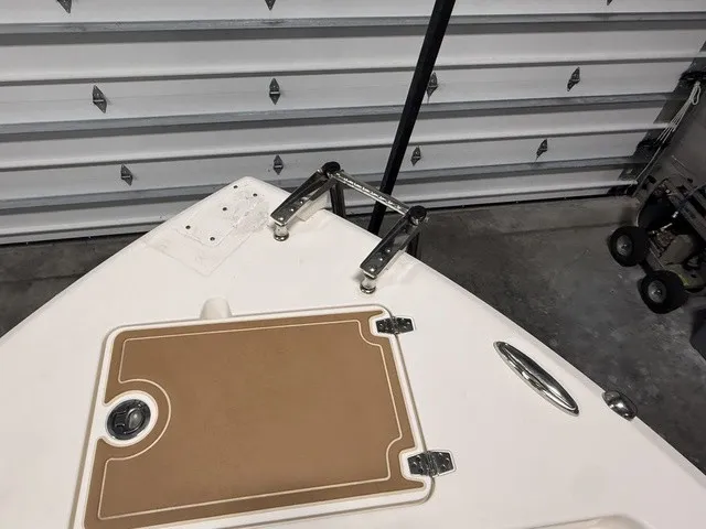 Slide: The Image of The bow of a 2020 Cobia 240DC boat with an anchor mount and storage compartment. - 33