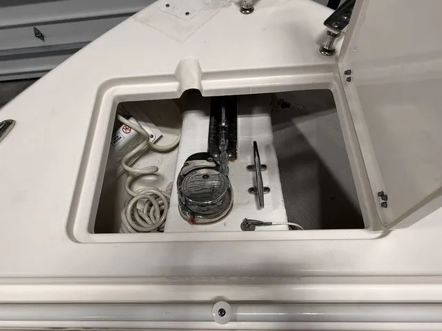 Slide: The Image of An open storage compartment on a Cobia 240DC boat reveals ropes and metal fittings. - 34