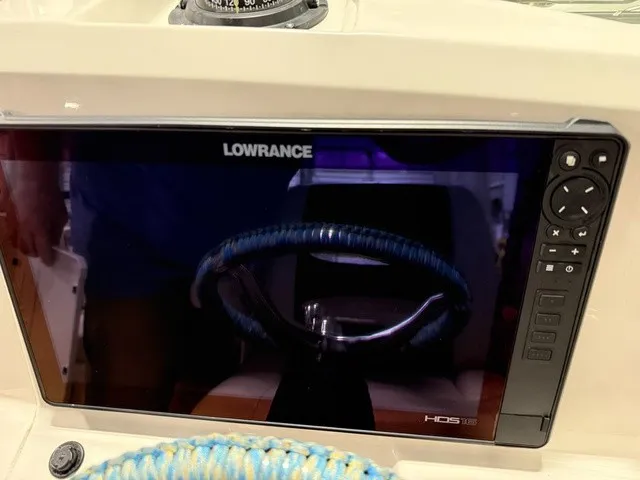 Slide: The Image of A Lowrance HDS display is mounted on a boat, with a blue-wrapped steering wheel below. - 21