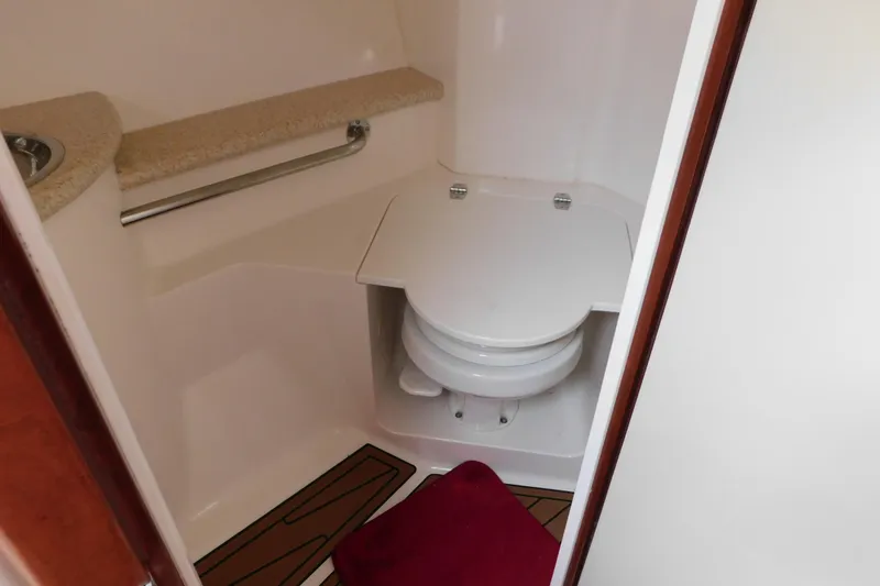 Slide: The Image of 2006 Fountain 38 LX boat bathroom with toilet, countertop, and red mat. - 58