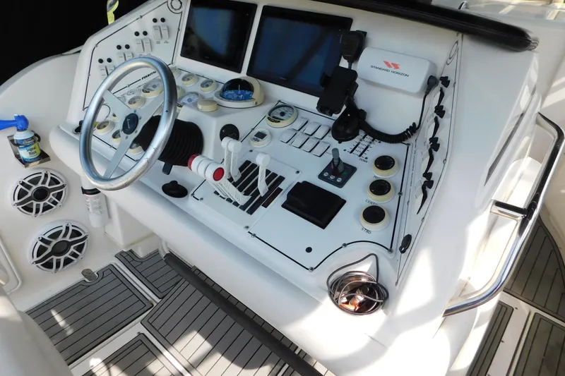 Slide: The Image of Control panel of a 2006 Fountain 38 LX boat with steering wheel and navigation equipment. - 21