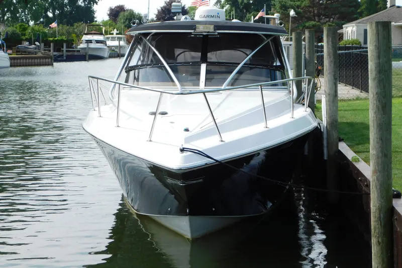 Slide: The Image of 2006 Fountain 38 LX boat docked in a serene marina setting. - 3