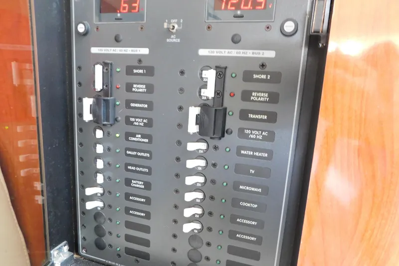 Slide: The Image of Electrical control panel on a 2006 Fountain 38 LX boat, featuring various switches and indicators. - 48