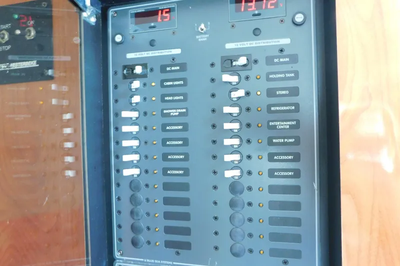 Slide: The Image of Electrical control panel on a 2006 Fountain 38 LX boat, featuring various switches and indicators. - 47