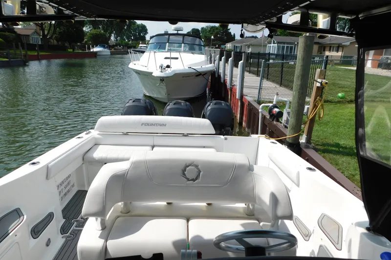 Slide: The Image of 2006 Fountain 38 LX boat docked in a serene canal setting. - 66