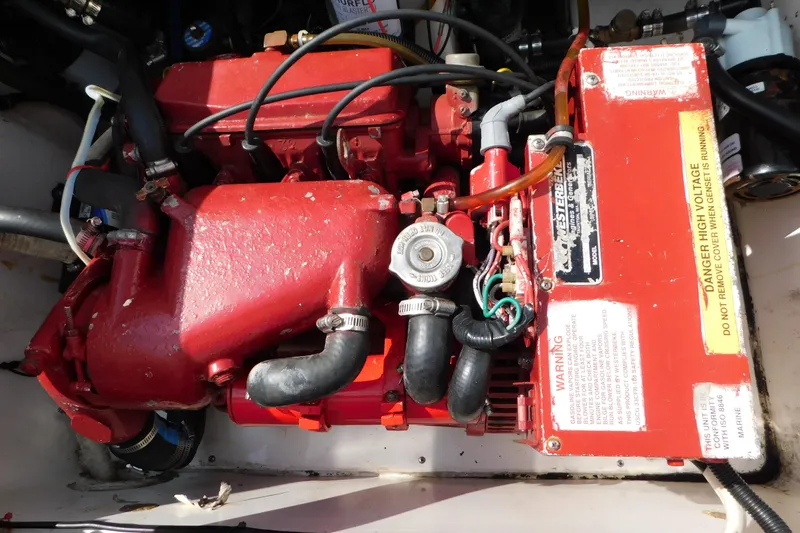 Slide: The Image of Engine compartment of a 2006 Fountain 38 LX boat, featuring red mechanical components. - 76