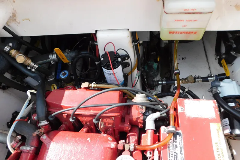 Slide: The Image of Engine compartment of a 2006 Fountain 38 LX boat, featuring red engine components. - 77