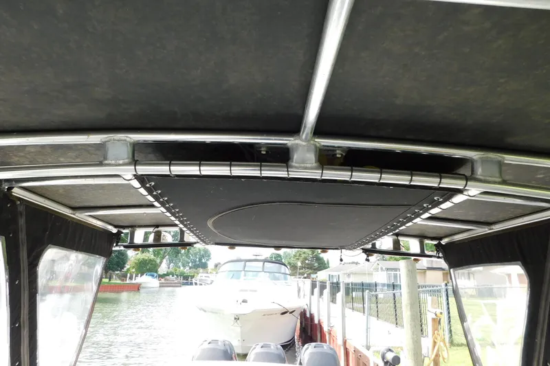 Slide: The Image of 2006 Fountain 38 LX boat interior view with canopy and docked surroundings. - 65