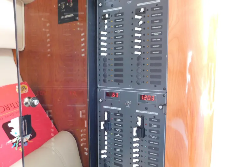 Slide: The Image of Electrical panel inside 2006 Fountain 38 LX boat, featuring various switches and digital displays. - 46