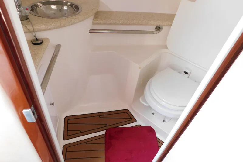 Slide: The Image of 2006 Fountain 38 LX boat bathroom with sink, toilet, and red mat. - 60
