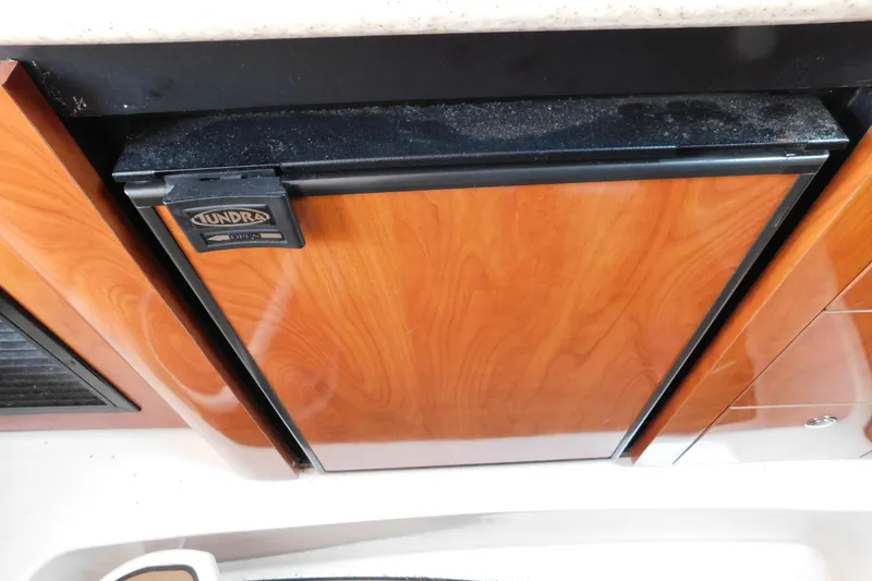 Slide: The Image of Wood-paneled Tundra fridge in 2006 Fountain 38 LX boat interior. - 55