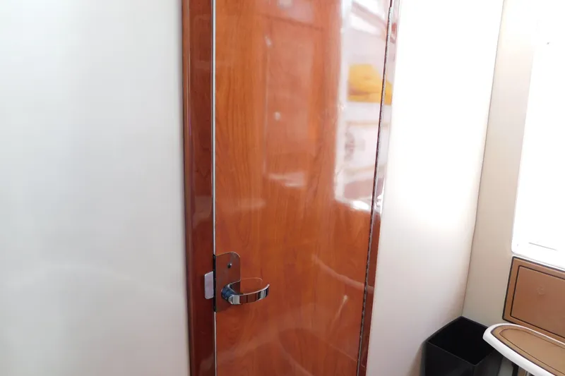 Slide: The Image of Wooden interior door on a 2006 Fountain 38 LX boat, featuring a sleek chrome handle. - 57