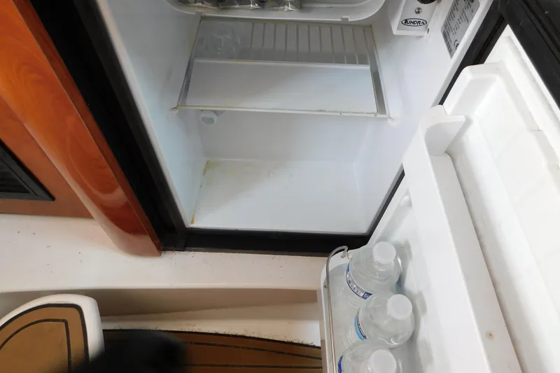 Slide: The Image of Open mini fridge on 2006 Fountain 38 LX boat with water bottles inside. - 56