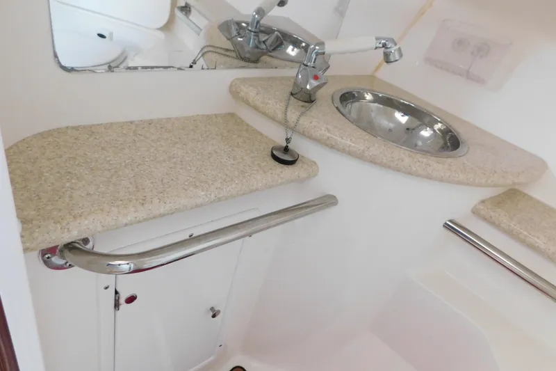 Slide: The Image of Compact bathroom sink area in a 2006 Fountain 38 LX boat, featuring a stainless steel basin. - 62