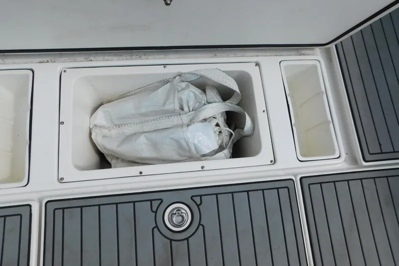 Slide: The Image of Storage compartment on a 2006 Fountain 38 LX boat with a white bag inside. - 68