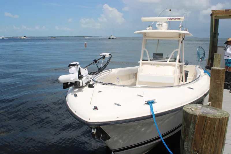 Slide: The Image of 2009 Pursuit C 310 Center Console boat docked by the water on a sunny day. - 4