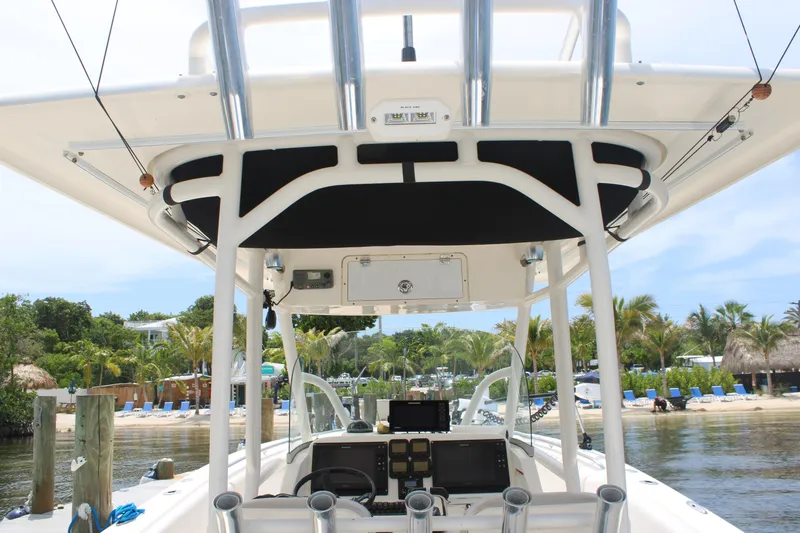 Slide: The Image of 2009 Pursuit C 310 Center Console boat docked near tropical beach resort. - 8