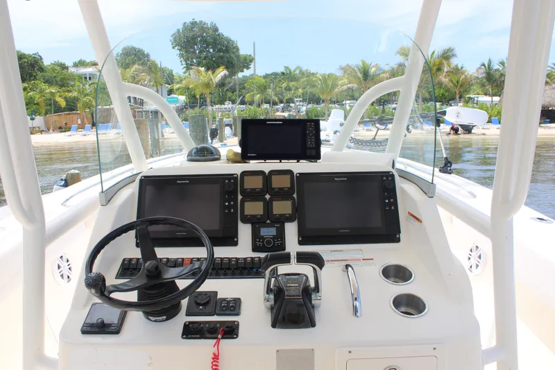 Slide: The Image of 2009 Pursuit C 310 Center Console boat dashboard with navigation screens and controls. - 10