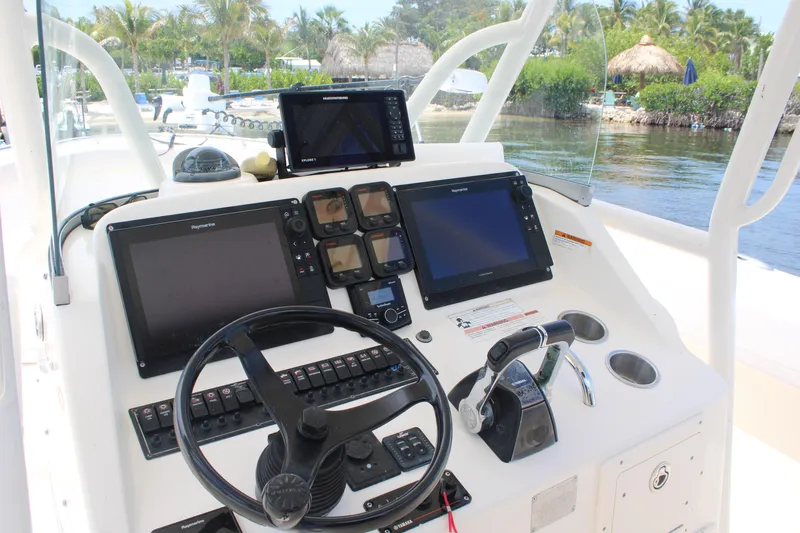 Slide: The Image of 2009 Pursuit C 310 Center Console helm with navigation screens and controls. - 9