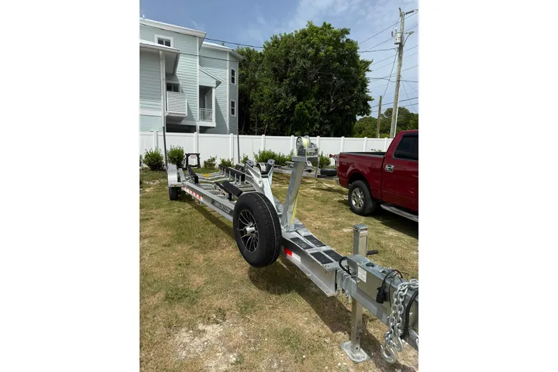 Slide: The Image of Trailer for 2009 Pursuit C 310 Center Console, parked beside a red truck. - 14