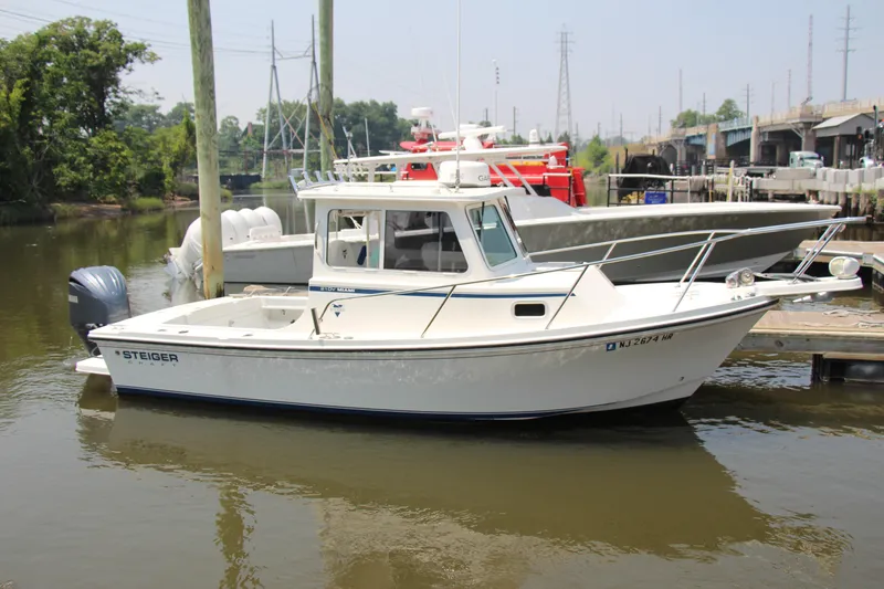 Slide: The Image of 2022 Steiger Craft 21 Miami boat docked in a marina, surrounded by calm waters. - 20