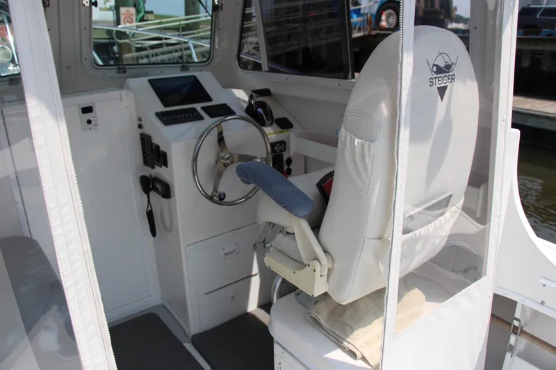 Slide: The Image of Interior of 2022 Steiger Craft 21 Miami boat, featuring helm and captain's chair. - 31