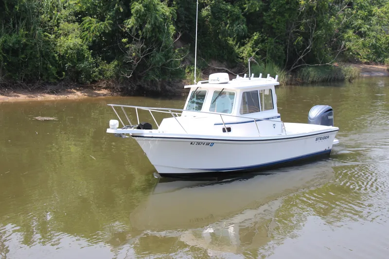 Slide: The Image of 2022 Steiger Craft 21 Miami boat on calm water near lush greenery. - 1