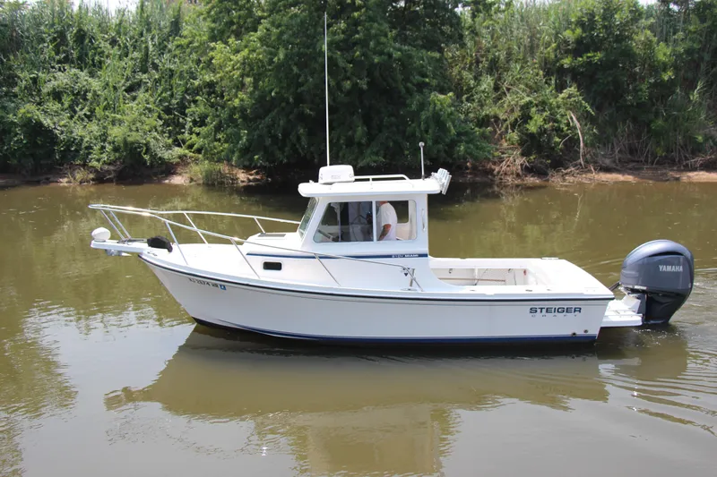 Slide: The Image of 2022 Steiger Craft 21 Miami boat on calm river, surrounded by lush greenery. - 5