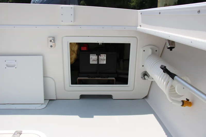 Slide: The Image of 2022 Steiger Craft 21 Miami boat interior with battery compartment and coiled hose. - 26