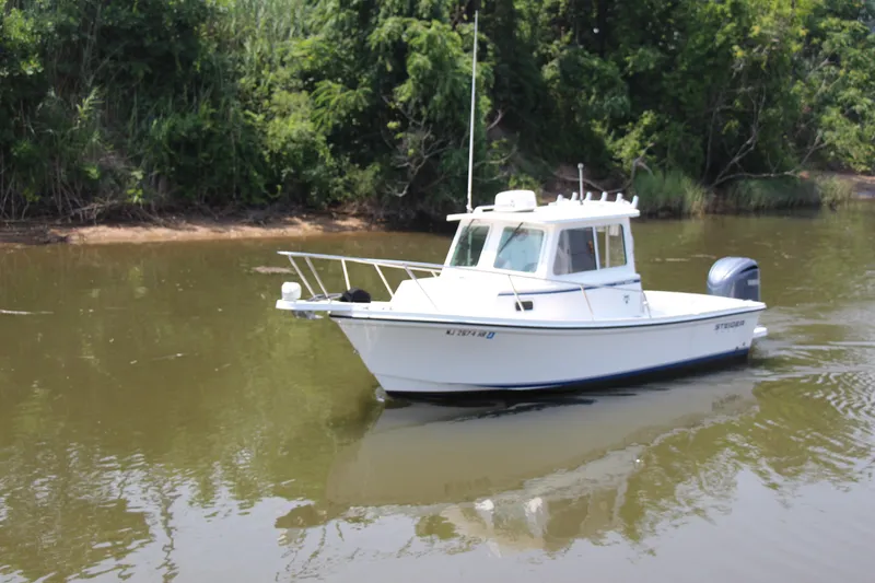 Slide: The Image of 2022 Steiger Craft 21 Miami boat on calm river with lush green background. - 2
