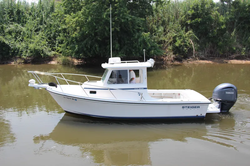 Slide: The Image of 2022 Steiger Craft 21 Miami boat on calm river with lush greenery background. - 4