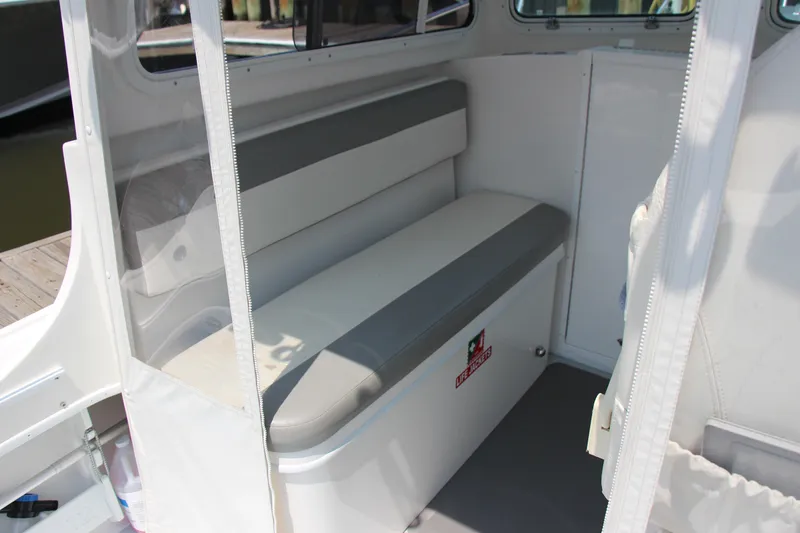 Slide: The Image of Interior seating of 2022 Steiger Craft 21 Miami boat, featuring cushioned bench and storage. - 30