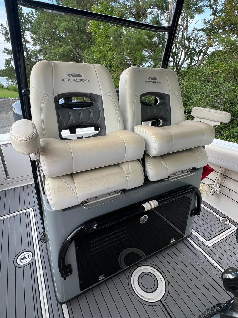 Slide: The Image of Two cushioned captain's chairs on a Cobia 280 Center Console boat, surrounded by a sleek deck. - 7