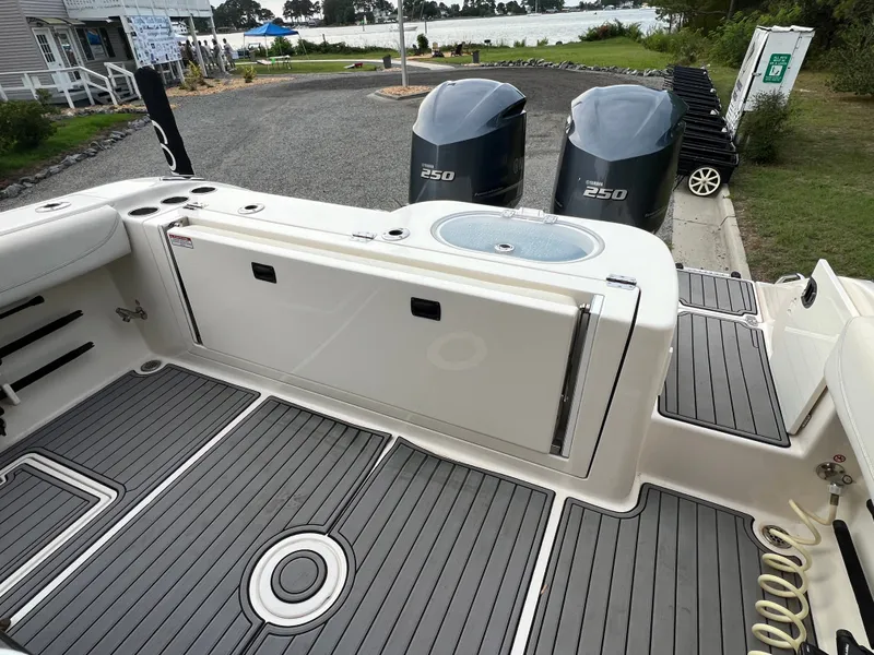 Slide: The Image of The image shows the stern of a 2020 Cobia 280 Center Console boat with two outboard engines. - 11