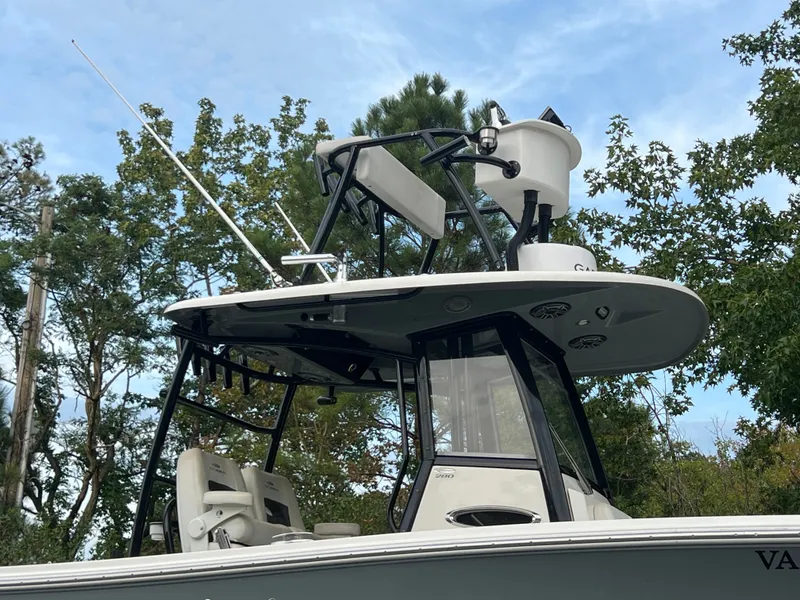 Slide: The Image of A 2020 Cobia 280 Center Console boat with a sturdy T-top and fishing rod holders. - 4
