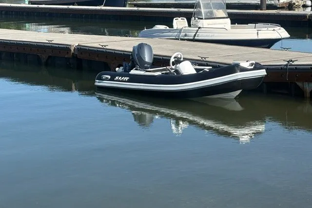 Slide: The Image of Schwarzes Schlauchboot am Dock mit Außenbordmotor. - 4