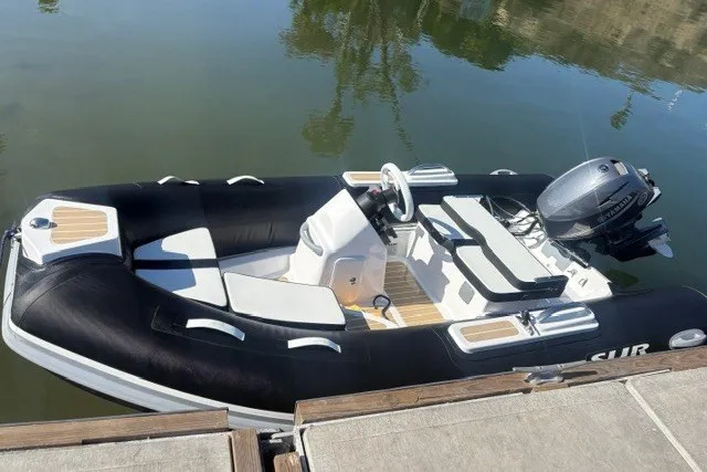 Slide: The Image of Das Bild zeigt ein schwarzes Schlauchboot von SUR Marine, Modell ST 330 Classic, am Wasser. - 3