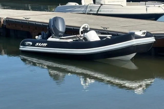 Slide: The Image of 2027 SUR Marine ST 330 Classic am Dock, schwarzes Schlauchboot mit Außenbordmotor. - 2