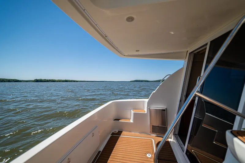 Slide: The Image of 2005 Meridian 341 Sedan yacht deck overlooking serene lake and clear blue sky. - 49