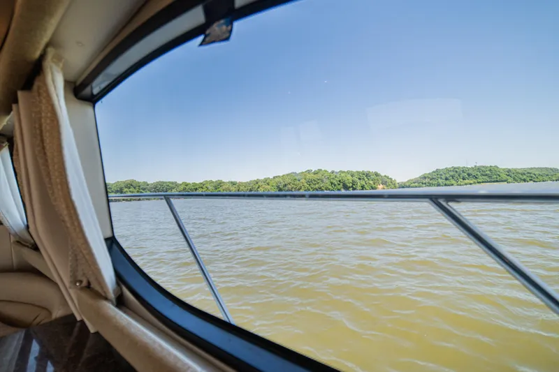 Slide: The Image of View from 2005 Meridian 341 Sedan window overlooking serene lake and lush green shoreline. - 40