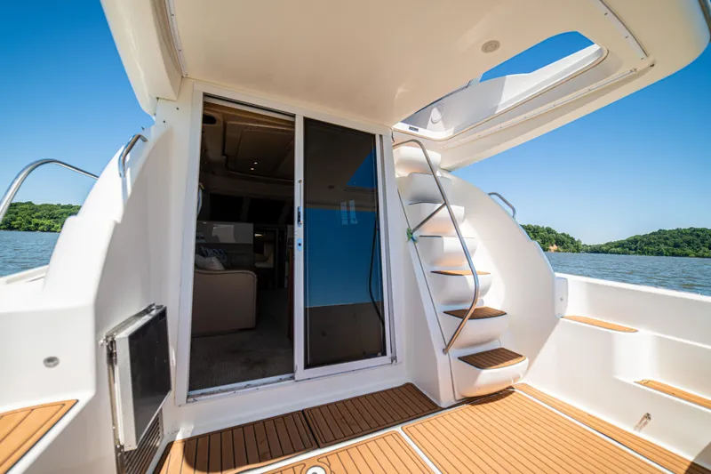 Slide: The Image of 2005 Meridian 341 Sedan yacht interior with stairs, overlooking serene water and lush greenery. - 48
